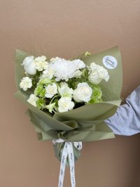 A soft green and white bouquet featuring white roses, carnations, lisianthuses, and chrysanthemums wrapped in olive green paper.