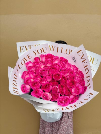 A bouquet of 100 peach roses wrapped in soft pink paper.