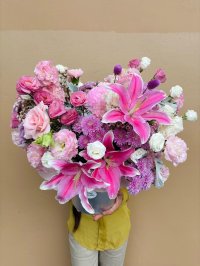 A pink hatbox bouquet of lilies, roses, lisianthuses, carnations, and chrysanthemums.