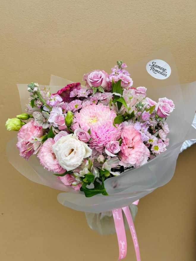 A pastel pink bouquet with roses, lisianthuses, chrysanthemums, and alstroemerias.