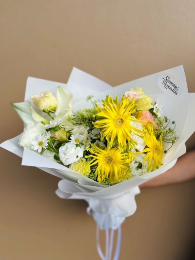 With golden-yellow gerberas, creamy roses, white daisies, and calla lilies, this bouquet dances in harmony between warmth and grace.