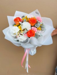 A cheerful bouquet of orange roses, yellow gerberas, white and pink carnations with silvery foliage.