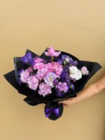 A bouquet of pink chrysanthemums, roses, and white lilies wrapped in pink paper