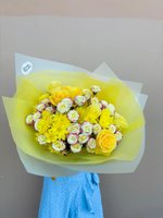 Hand-tied bouquet with yellow roses, yellow chrysanthemums, and white spray roses with pink edges, wrapped in yellow and white tissue paper