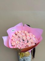 Soft pink rose bouquet wrapped in pink and gold paper with dewy petals.