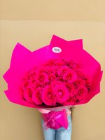 A bold bouquet featuring vivid hot-pink roses wrapped in bright pink paper.
