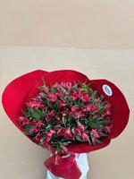 Elegant hand-tied bouquet of fifteen burgundy and red alstroemeria flowers with green foliage, wrapped in red paper against a neutral background