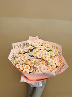 Cream and peach rose bouquet wrapped in pastel paper with gold lettering that says “Every Day I Love You.”