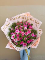 Large bouquet of vibrant pink roses with greenery, wrapped in blush paper with gold text.