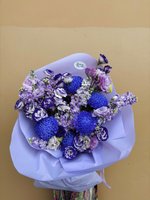 Bouquet with purple and white flowers wrapped in lavender paper.
