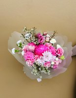 Pink and white flower bouquet with roses, lilies, and orchids wrapped in translucent paper