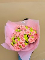 Bouquet of pink roses and green chrysanthemums wrapped in soft pink paper.