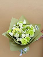 A fresh bouquet featuring green carnations, white roses, and chrysanthemums wrapped in olive green paper.