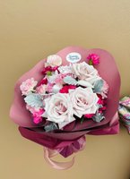 Becca bouquet featuring three pale pink roses and eight pink and fuchsia carnations wrapped in pink paper with ribbon