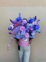 Pink, purple, and white bouquet with roses, lilies, and orchids in a decorative pink box