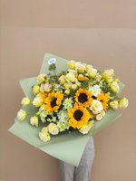 Hand-tied bouquet with three bright orange and yellow sunflowers, cream colored roses, white chrysanthemums, and baby's breath, wrapped in sage gre...