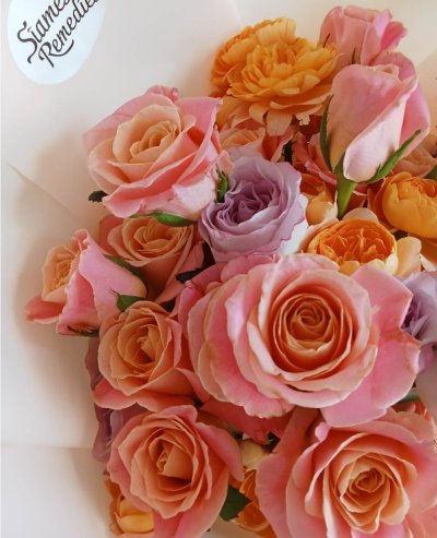 Elegant peach and pink roses with purple accents in a romantic Phuket flower bouquet featuring lush carnations.
